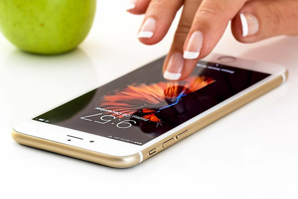 smartphone blanc avec doigts de femme sur écran